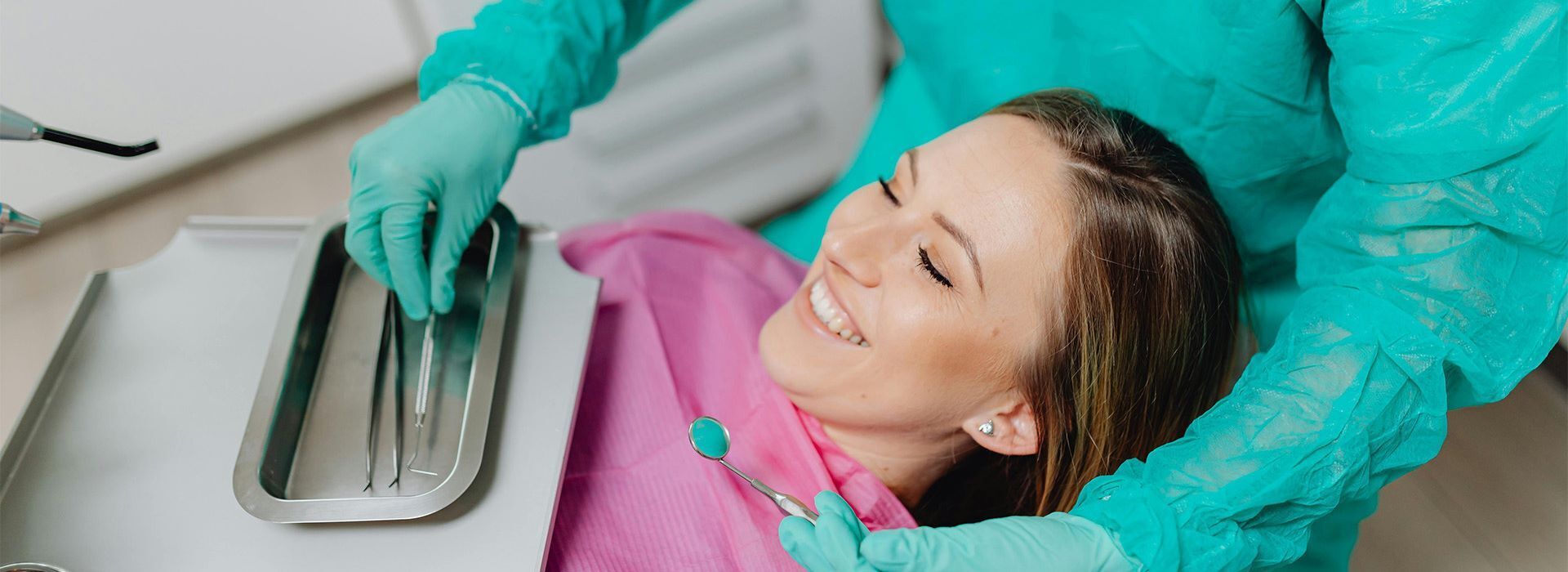 dentist cleaning female patient's teeth